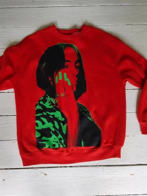 Billie Eilish sweatshirt - Billie Eilish tröja från HM. Svart/grönt tryck av Billie på framsidan och grön text "Billie Eilish" på baksidan.
