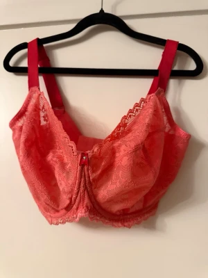 Rosa spets-bh från Freya/70M - Säljer en snygg rosa bh från Freya med vacker spets och dekorativ rosett framtill. Bh:n har breda axelband och mjuka kupor utan vaddering. Materialet är en blandning av polyamid, polyester och elastan för skön passform.