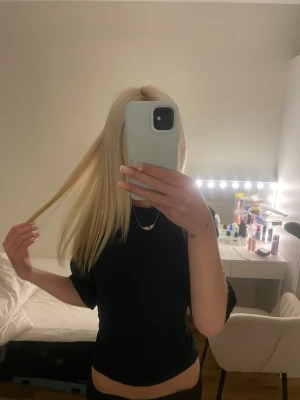 Svart croppad topp med knyt från nelly  - Snygg svart croppad topp med korta ärmar och knyt i ryggen. Toppen har en tight passform.