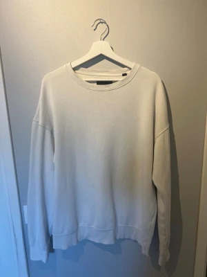 Vit sweatshirt från Jack & Jones strl m - En stilren vit sweatshirt från Jack & Jones med rund halsringning och ribbade muddar vid ärmslut och nederkant. Tröjan har en avslappnad passform och är tillverkad i mjukt bomullsmaterial. Perfekt för en clean och enkel look.