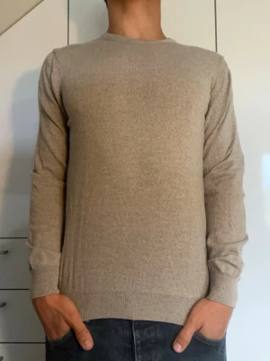 Beige tröja från Stenströms  - Beige tröja från Stenströms tillverkad i 100% bomull. Det står att det är en Large men den sitter som S. Inga defekter. Modellen är 178 cm och väger 77 kg. Hör gärna av dig vid frågor!