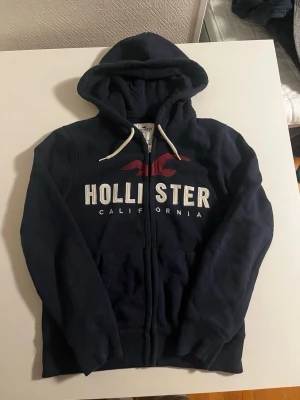 Hollister California zip hoodie  - Riktigt snygg och eftertraktad Hollister California zip hoodie. fint skick inga fel storlek S kan även passa M kan ta mått vid behov. Endast 428 kr ej hugget i sten kom gärna med frågor och prisförslag har även mycket mer liknande i min profil alla storlekar kolla gärna stor rabatt vid köp av flera 😁✌️