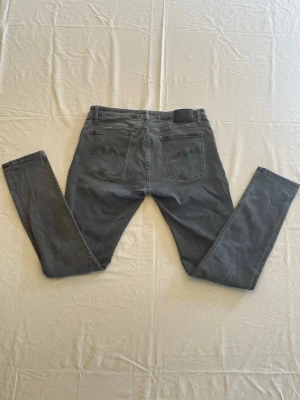 Grå slim fit jeans - Snygga grå slim fit jeans med klassisk femficksdesign och raka ben. Jeansen har två bakfickor och är tillverkade i ett mjukt denimtyg som ger en skön passform. Perfekta för en avslappnad och trendig stil.                                  Tveka inte, hör av er vid intresse, frågor eller prisförslag!