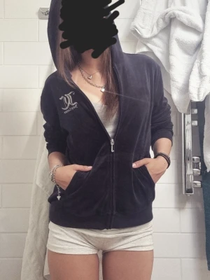 Juicy Couture vintage velour hoodie - Juicy Couture hoodie i mörkblå velour med dragkedja och huva. Klassisk logga broderad på bröstet i vitt. Mjuk och skön känsla, perfekt för en avslappnad och trendig look. Fickor framtill och ribbade muddar vid ärmslut och nederkant. INGA defekter alls och är i perfekt skick🫶🏽 Säljer pga kommer ej till användning
