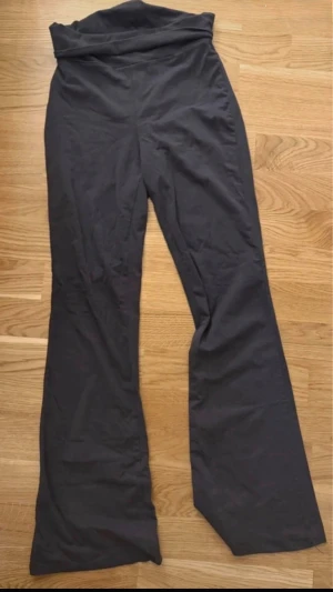 Grå yoga pants - Säljer ett par grå leggings med bootcut-modell. De har hög midja och är tillverkade i ett stretchigt material som sitter skönt på kroppen. Perfekta för dig som gillar en avslappnad men trendig look. Ifrån gina tricot