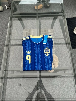 Sverigetröja – Isak #9 🇸🇪 - Säljer en riktigt fräsch Sverigetröja med Alexander Isak #9 på ryggen! ⚽️ Tröjan är helt ny med lappar kvar. Snygg blå design med gula detaljer, perfekt att rocka till vardags eller på läktaren. Den har en skön passform och lätt material som andas.  Storlek: M  Skick: Helt ny/oanvänd. Skicka ett DM om du vill köpa eller har några frågor! 📩 