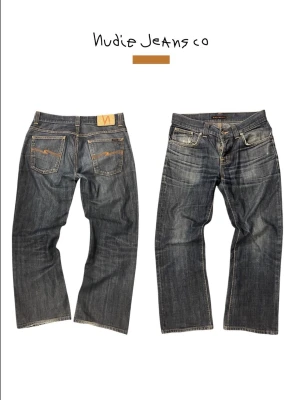 Nudie Jeans blå raka boot cut Ola archive eftertraktade - Ett par klassiska blå jeans från Nudie Jeans med raka ben och kontrastsömmar. Jeansen har fem fickor, orange broderi på bakfickorna och en patch i läderimitation vid linningen. Tillverkade i slitstark denim, perfekt för en avslappnad stil. Modell 173cm