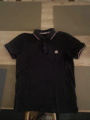  Moncler Polo Navy - Säljer en marinblå pikétröja moncler nästan oanvänd! Fraktar direkt och plagget har inga skador ✅ Passar S/M