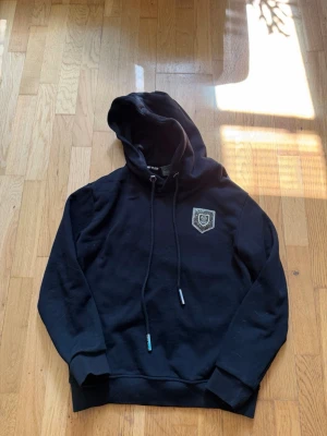 Svart hoodie från Philipp Plein med tiger - Säljer min Philipp Plein hoodie i storlek S. Den är i väldigt fint skick och har endast använts ett fåtal gånger, vilket gör att den fortfarande känns fräsch. Inga hål, fläckar eller andra skador.