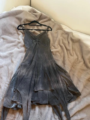 Asymmetrisk klänning med spets - Unik grå klänning med asymmetrisk nederkant och smala axelband. Storlek S