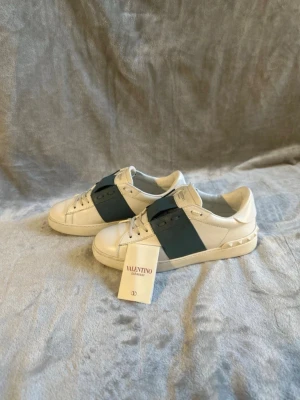 Valentino Garavani vita sneakers - Snygga vita sneakers från Valentino.Dem mesta populära skorna på marknaden just nu ✅😁🤝📦vi kollar igenom våra skor noggrant så att dem är 100% äkta 📦📦😁✅🚛SKICK 9/10  på köpet får man med ett valentino kort 😁priset är inte hugget i sten och kan diskuteras 💸