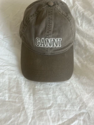 Ganni keps grön - Så fin ganni keps, köpt i Milano på Rinascente(deras nk). Endast använd 1 gång. Köpt för ca 900kr