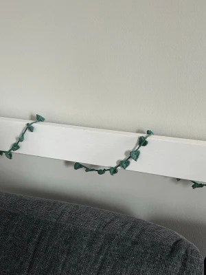 Grön virkad girlang med blad - Handgjord grön virkad girlang med små blad, perfekt som dekoration till vägg, hylla eller sänggavel. Girlangen är gjord av bomullsgarn och har en naturlig, bohemisk känsla som passar bra i sovrum eller vardagsrum. Längd kan önskas, 100 kr/meter. 