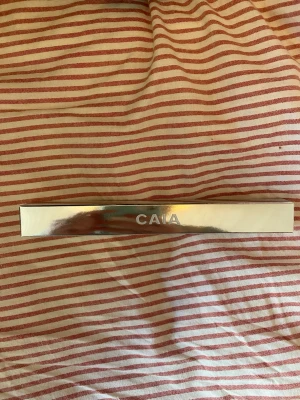CAIA F20 sminkborste i silver - Snygg sminkborste från CAIA i modellen F20. Nypris: 225 kr,    Borsten har ett stilrent silverfärgat handtag med CAIA-loggan och är perfekt för applicering av puder eller foundation. Kommer i en elegant, fyrkantig design som känns lyxig och modern.