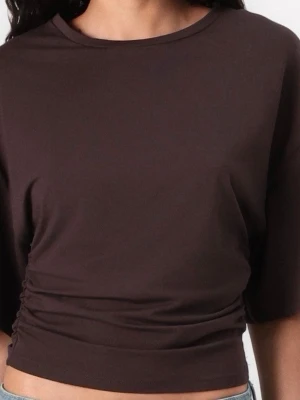 Brun topp  - Snygg brun topp med korta ärmar, Toppens material känns mjukt och lätt, perfekt för en avslappnad stil. Passformen är normal och toppen har en enkel, stilren design. Åtdragen vid midjan.