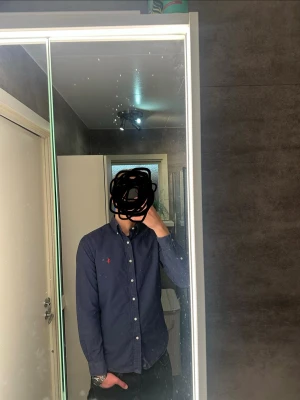 Ralph Lauren skjorta marinblå - En fin Ralph Lauren skjorta. Den är perfekt för festligheter. Skjortan är använd men har ej någon fläck. 