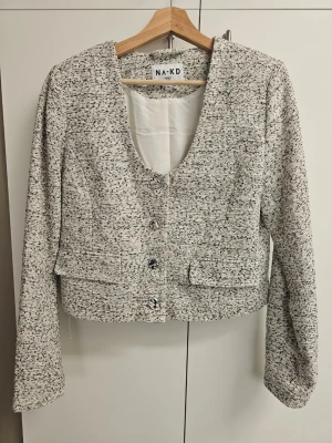 Croppad blazer - NA-KD - I jättefint skick. Använd fåtal gånger. Kortare modell. Fickorna är fejk.