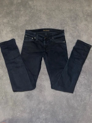 Svarta slim jeans från Nudie - Säljer ett par riktigt nice svarta nudie jeans. Jeansen är i fint skick, inga konstigheter. Storlek w26 l32, passar bra på någon runt 160-165. Hör av dig direkt vid frågor eller funderingar!😄