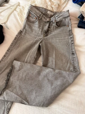 Grå jeans från Gina Tricot - Högmidjade gråa jeans med vida, raka ben. Har klippts i benen för att passa mig (160 cm) använda fåtal gånger endast 