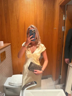 Gul balklänning - Såå fin balklänning i satin💞Jag råkade stryka klänningen vilket gav den ett märke som visas på bilden, den är även lite nopprig på ena sidan och har lite små skavanker som visas på bilderna. Själv hade jag väskan precis över brännmärket vilket jag tyckte löstes ganska bra😇😇