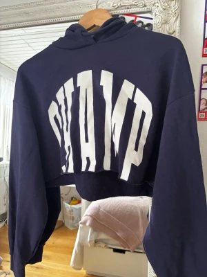 Blå hoodie - En mörkblå cropped hoodie med texten ”champ”. Säljer då jag inte använder den. Storlek M men skulle säga passar S också!