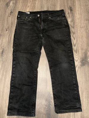 Svarta raka jeans från Levi's Premium - Säljer ett par svarta jeans från Levi's Premium med rak passform och klassisk femficksdesign. Jeansen har dragkedjegylf och silverfärgade nitar. Perfekta för en avslappnad och stilren look.