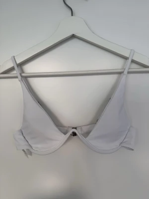 Vit bikiniöverdel med bygel  - Snygg vit bikiniöverdel med bygel och smala axelband. från Shein i strl S. Aldrig använd.