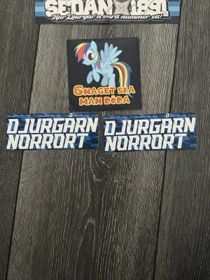 Djurgården och My Little Pony klistermärken - Säljer ett set med fyra klistermärken: två blåvita 'Djurgårn Norrort', ett svart med My Little Pony och texten 'Gnaget ska man döda', samt ett blått 'Sedan 1891'. Perfekt för dig som gillar Djurgården och vill ha unika stickers.