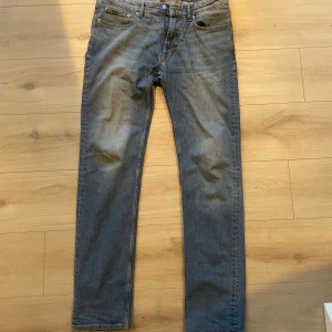Blå jeans från Dressmann 32/34 - Klassiska blå jeans från Dressmann i rak modell. Jeansen har fem fickor, normal passform och är tillverkade i slitstarkt bomullstyg. Perfekta för dig som gillar en enkel och tidlös stil.