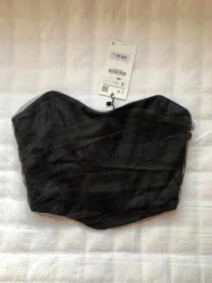 Svart korsett croptop från Zara i mesh tyg - Bredd: 35cm Längd: 28cm  Jättefin off shoulder korsett topp från Zara i mesh tyg på utsidan. Väldigt inne nu med korsett toppar. Bilden på tredje bilden är från Zaras hemsida.  Jag har även jättebra bundlerabatt och kika även på andra artiklar jag har för att få till bra pris! Pris kan diskuteras vid snabbaffärr!  Djurfri och rökfri hem! Hör av dig vid fler frågor, jag svarar snabbt!