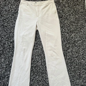 Bikbok beige utsvängda kostymbyxor - Säljer ett par stilrena beigea kostymbyxor. Byxorna har hällor för skärp, diskreta fickor bak och stängs med dragkedja och knapp framtill. Lappen är bortklippt men skulle säga att dom typ är strl M🩷