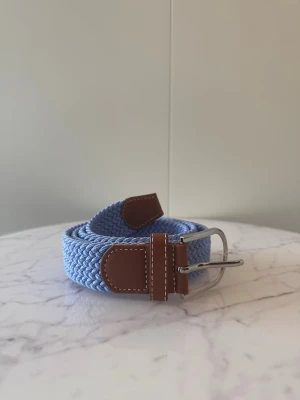 Blått flätat bälte - Tja säljer helt nytt klassiskt svenskt flätat bälte från Bältgallerian i storlek 105cm i längd och 3,5cm i bredd. Dem är i ett elastiskt material och finns i flera olika färger i min profil.