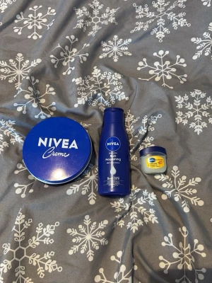 Hudvårdspaket från Nivea och Vaseline - Helt oanvänd.Säljer ett hudvårdspaket med Nivea Creme i stor blå plåtburk, Nivea Rich Nourishing body lotion i blå plastflaska och en liten burk Vaseline Lip Therapy. Perfekt för återfuktning av hud och läppar.