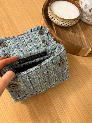 Kurt geiger väska  - Säljer en snygg grön tweed handväska från kurt geiger med kedjerem. Super fin och inte så synligt använd. Nypris 2100kr