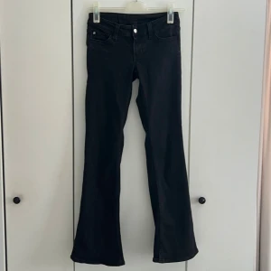 Svarta bootcut jeans från Cheap Monday - Snygga svarta jeans från Cheap Monday med bootcut-modell och klassisk femficksdesign. Jeansen har en rosa logga bak i midjan och är tillverkade i ett stretchigt material för skön passform. 
