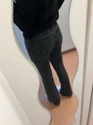 Gina, Svarta bootcut jeans  - Säljer ett par svarta bootcut jeans från gina tricot med klassiska fem fickor och normal midja. Jeansen har en lätt tvättad look och är tillverkade i stretchigt denimtyg och sitter väldigt skönt. Storlek 36.
