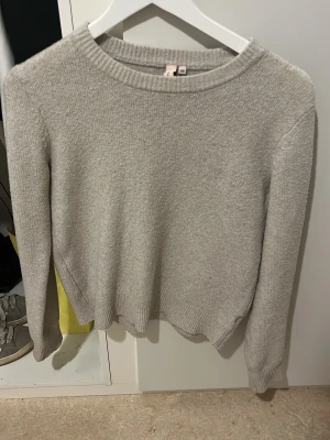 Ljusbeige  stickad tröja  - En enkel och stilren ljusbeige stickad tröja från Nelly med rund halsringning och ribbade muddar vid ärmslut och nederkant. Perfekt för lager-på-lager och passar till jeans eller kjol. Materialet är mjukt och behagligt. Noppig 