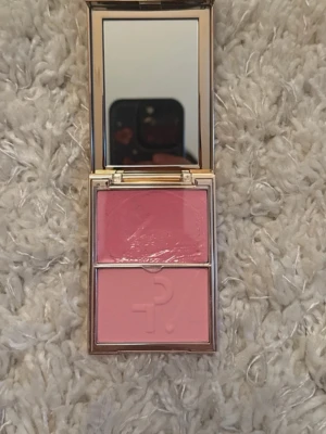 Patrick Ta dubbelrouge i rosa nyanser - Snyggt rouge från Patrick Ta med två rosa nyanser – en krämig och en puderformula. Kommer i en lyxig guldig dosa med spegel. Perfekt för att skapa en fräsch och naturlig look med både lyster och färg. Nyans: JUST ENOUGH