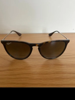 Ray-Ban bruna solglasögon - Snygga solglasögon från Ray-Ban med bruna runda bågar och tunna silverfärgade skalmar i modellen Erika. Sparsamt använda och är i mycket bra skick. 