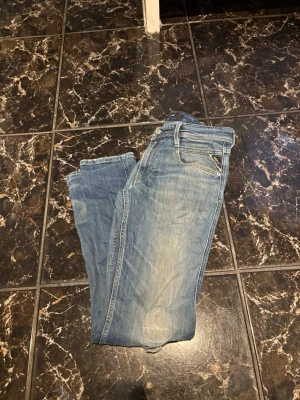 Replay Jeans - Anbass  - Hej säljer nu ett par Replay Anbass Jeans. Jeansen är använda och i ett okej skick. Byxan har ett hål vid knä skålen. Storlek 29/32
