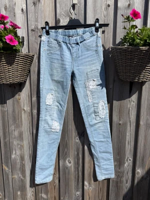 Ljusa slitna jeans från KappAhl (strl 158) - Säljer ett par ljusblå jeans från KappAhl med resår i midjan och flera slitna detaljer på benen. Jeansen har smal passform och klassiska fickor fram och bak. obs fickorna framtill är enbart för design så inga riktiga. Perfekta för en avslappnad och trendig look.