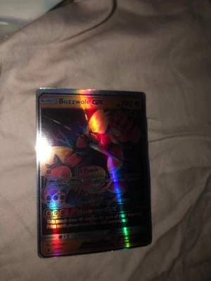 Pokémon GX-kort Buzzwole & Trevenant - Två Pokémon GX-samlarbilder: Buzzwole GX och Trevenant & Dusknoir GX Tag Team. Båda korten är holografiska och har färgstarka motiv med metallic-effekt. Perfekt för samlare eller Pokémon-fans som vill utöka sin kortsamling.