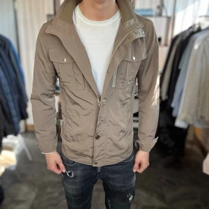 Brun tunn field jacket -  Mycket bra skick med en liten defekt, en fläck på ryggen sol syns på sista bilden. Nypris ca 3000kr. Passar dig som är 175-185cm ungefär. Modellen är 185 cm, 75 kg. Alltid billigare pris vid köp av flera varor‼️🙌Svarar alltid på frågor eller funderingar! 