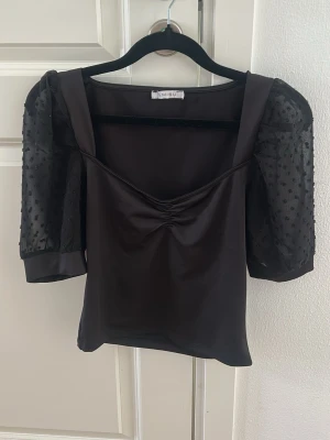 Svart topp med puffärm NewYorker  - Super söt topp från NewYorker, helt oanvänd, den har puffärmar i mesh och söta små prickar🌸  Storlek XS