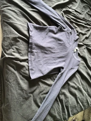 Mörkblå långärmad topp Divided - En enkel och stilren mörkblå långärmad topp från H&M Divided. Modellen är rak med rund halsringning och tillverkad i mjuk bomull. Perfekt att matcha med jeans eller kjol för en clean look.