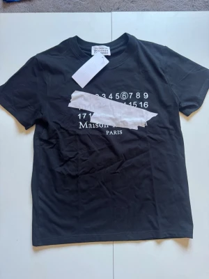 Maison margiela t shirt - En väldigt fin maison margiela Tshirt som nästan aldrig är använd.  -Svart -Stilren till sommaren -Köpt i Sverige -Tvättad en gång enligt skötselråd Skriv i pm för mer info!😊