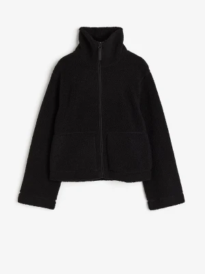 Svart teddyjacka med hög krage - Mysig svart teddyjacka med hög krage och hel dragkedja framtill. Jackan har två stora fickor och är tillverkad i fluffigt teddy-material som ger en cool och avslappnad look. Perfekt för lager-på-lager och streetstyle.