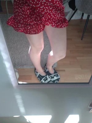 Röd kortkjol med vita hjärtan - Supersöt röd kortkjol med vitt hjärtmönster och volangkant. Kjolen har en lekfull och trendig look, perfekt för dig som vill sticka ut. Materialet känns lätt och flowy, vilket gör den skön att bära under varma dagar. Perfekt för alla hjärtans dag! Säljs då jag tycker den är för kort 