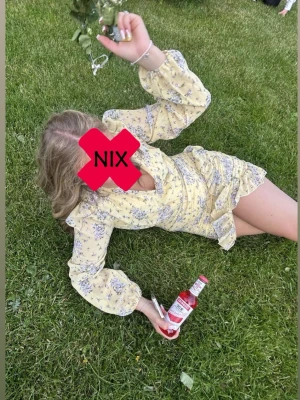 Gul blommig omlottklänning volang - Söt gul kortklänning med blommigt mönster och volangdetaljer. Klänningen har omlottmodell, v-ringning och långa ärmar med resår vid armarna. As nice till midsommar/student osv. ANVÄND EN GÅNG