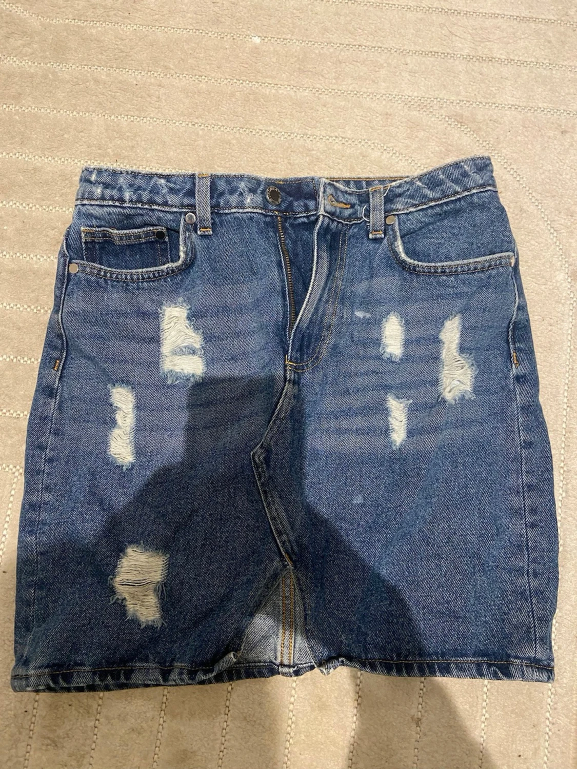 Blå jeanskjol med slitningar